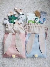 Load image into Gallery viewer, bunny bag in peachy pink and baby blue linen with bunny ears and fluffy tail. Great to use as slippers bag, toys bag or diaper container.
