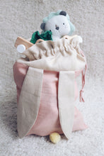 Load image into Gallery viewer, bunny bag in peachy pink linen with bunny ears and fluffy tail. Great to use as slippers bag, toys bag or diaper container.