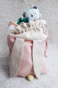 bunny bag in peachy pink linen with bunny ears and fluffy tail. Great to use as slippers bag, toys bag or diaper container.